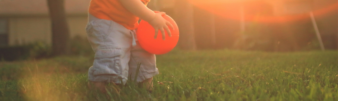 Child playing outside with ball