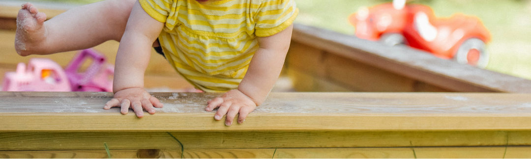 Child playing outdoors in sandbox